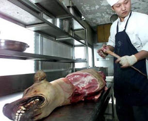 A butcher slicing up a dog into meat for dinner